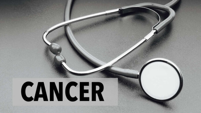 A stethoscope on a dark surface with the word 'CANCER' prominently displayed