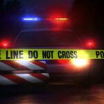 Car Bomb Horror Hits Athletic Club Police car with flashing lights behind caution tape.