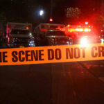 One Runner Sparks Chaos: 19 Injured! Crime scene tape with emergency vehicles in background.