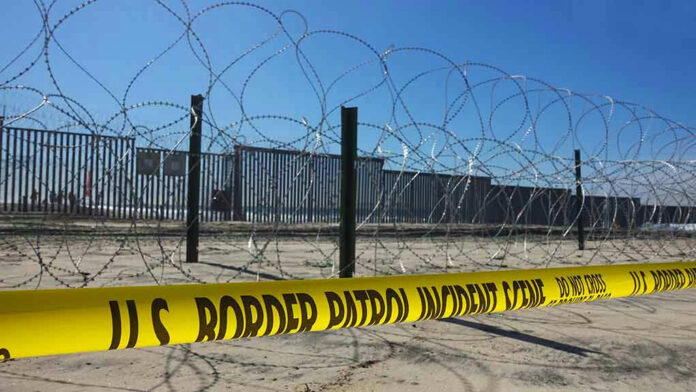 1242590464 Border patrol tape and barbed wire fence.