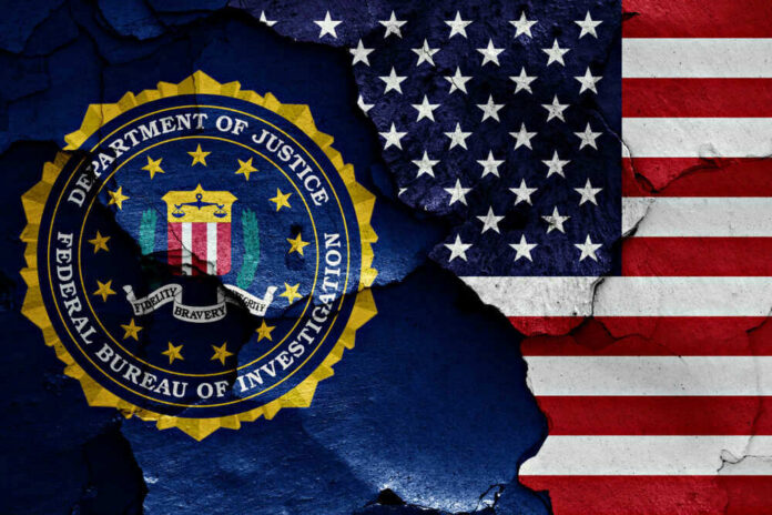 shutterstock_1023380488 FBI seal superimposed on cracked American flag.