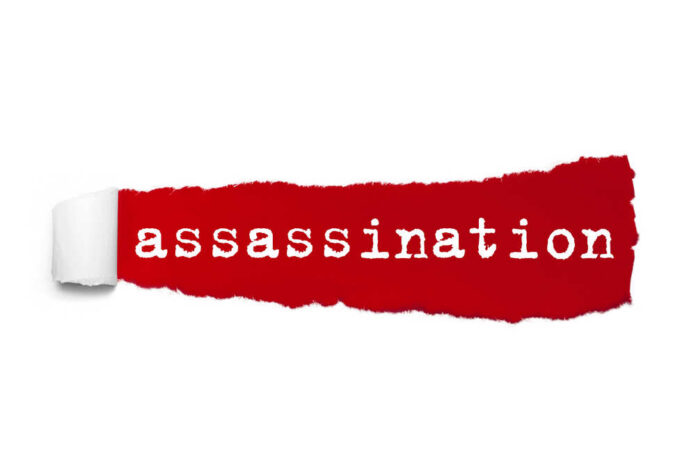 Word,Assassination,Written,Under,The,Curled,Piece,Of,Red,Torn The word 'assassination' printed on a red torn paper background