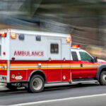 Burn Hazard Lurks in THIS Budget Appliance?! Red and white ambulance driving on a city street.