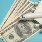 Fuel Shock Triggers Sudden Airliner Route Freeze A model airplane placed on top of dollar bills