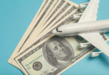 Fuel Shock Triggers Sudden Airliner Route Freeze A model airplane placed on top of dollar bills