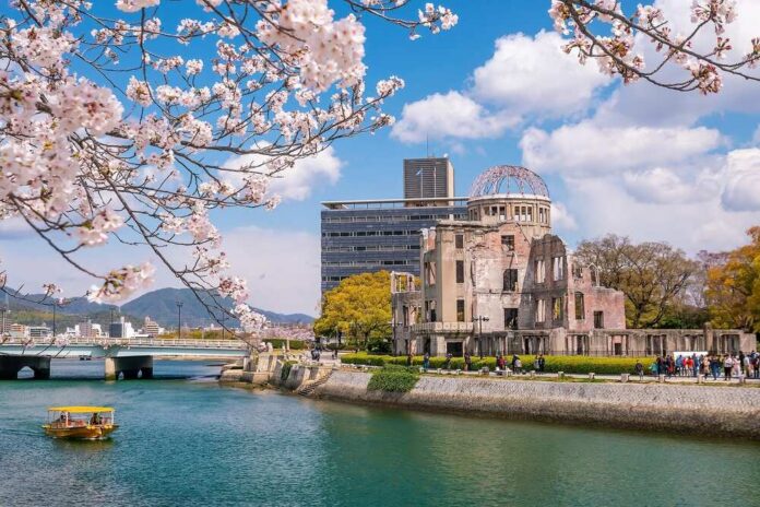 Hiroshima,Atomic,Bomb,Dome,And,The,Cherry,Blossom,In,Kobe, View of the Hiroshima Peace Memorial with cherry blossoms in the foreground