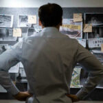 Supreme Twist In Etan Patz Murder Mystery Man examining investigation board with photos and notes.