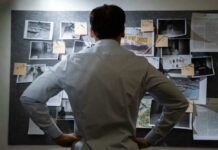 Supreme Twist In Etan Patz Murder Mystery Man examining investigation board with photos and notes.