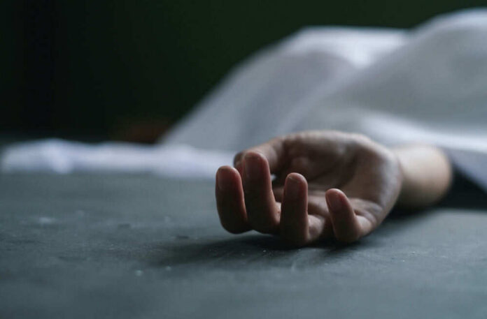 shutterstock_2193737127 Dead persons hand lying on a gray surface