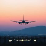 Fake Airline Captain? Police Launch Investigation An airplane approaching for landing against a colorful sunset sky