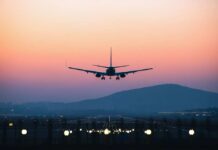 Fake Airline Captain? Police Launch Investigation An airplane approaching for landing against a colorful sunset sky