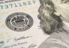 Savings Cliff: America’s Savings Vanishing Close-up of U.S. banknote with Federal Reserve seal and portrait detail