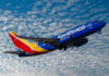 Southwest Backtracks Angering Many Customers Southwest airplane on the air with blu sky and white clouds.