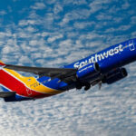 Southwest Backtracks Angering Many Customers Southwest airplane on the air with blu sky and white clouds.