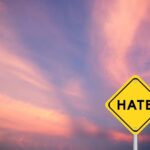 Alleged Hate Plot Targets Pro-Israel Office Yellow warning sign with the word HATE against a colorful sunset sky