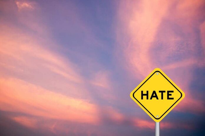 Yellow,Transportation,Sign,With,Word,Hate,On,Violet,Color,Sky Yellow warning sign with the word HATE against a colorful sunset sky
