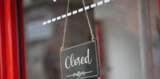 A closed sign hanging on a shop window