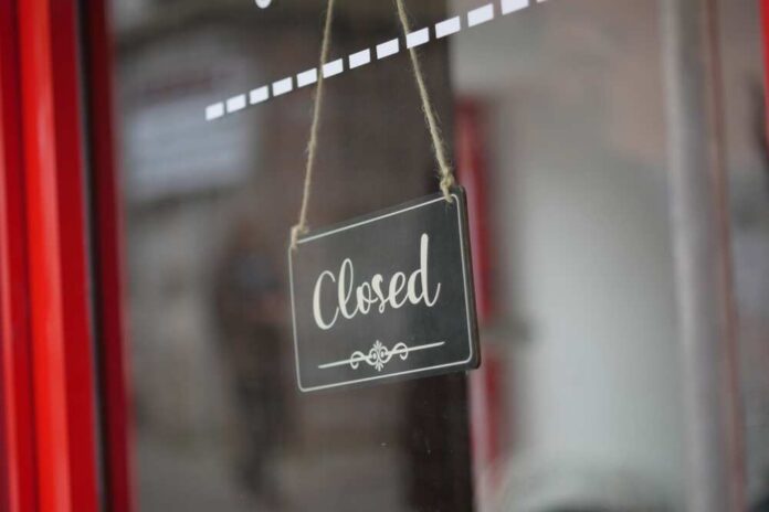 Closed,Sign,Hanging,On,A,Cafe,Door,During,Business,Hours A closed sign hanging on a shop window