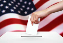 Georgia Showdown Underway — Senate Control at Stake Hand dropping ballot into box, American flag background.