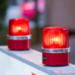 Back Seat Lunges — Automaker Sounds Alarm red warning beacons on a barrier