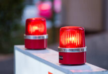 Back Seat Lunges — Automaker Sounds Alarm red warning beacons on a barrier