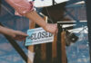 Pizza Chain Freefall: 50 Shops Vanish Person flipping closed sign on glass door