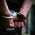 Holiday Fireworks Blast Turns Deadly — Arrest Follows Close-up of hands in handcuffs behind back.