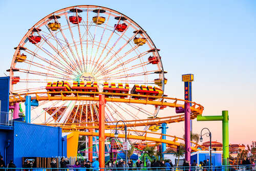 Santa,Monica,,Usa,-,December,27,,2015:,Ferris,Wheel,And Colorful amusement park scene featuring a ferris wheel and roller coaster at sunset