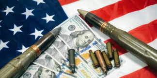 American flag with money bullets and weapons on top