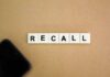 Letter tiles spelling recall on cardboard with a smartphone corner
