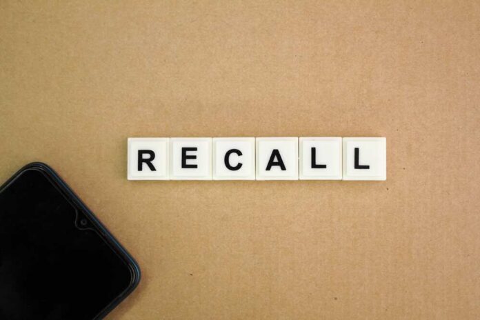 Letter tiles spelling recall on cardboard with a smartphone corner