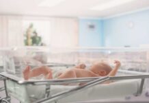Billionaire Blast: $6.25B For Kids Newborn baby lying in a transparent crib in a hospital nursery