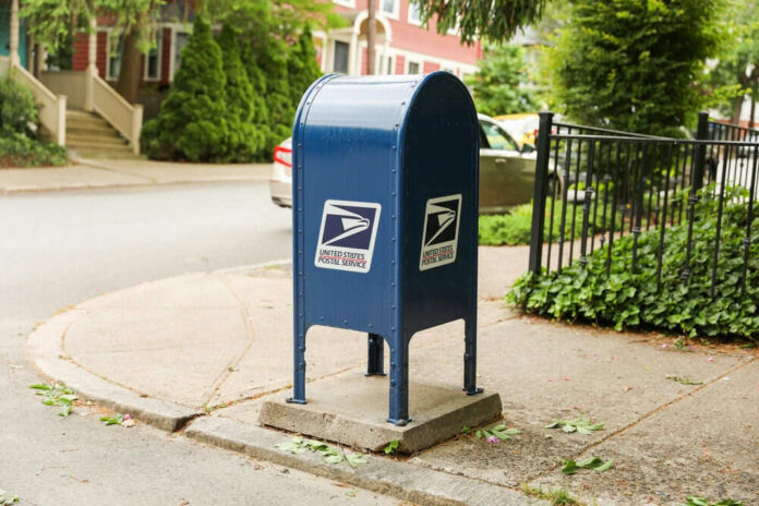 shutterstock_2315960123 Blue USPS mailbox on a residential street corner.