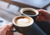 Two hands holding cups of coffee, latte and black coffee