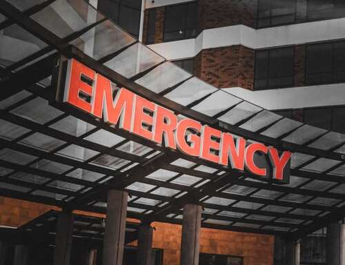 Emergency,Room:,Immediate,Care,Required Illuminated emergency sign at a hospital entrance