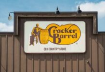 Biscuit Bloodbath at Cracker Barrel Sign for Cracker Barrel Old Country Store featuring a man sitting on a barrel
