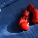 An empty boxing ring illuminated by bright lights in a sports arena