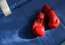Boxing Phenom Killed In Deadly Hit An empty boxing ring illuminated by bright lights in a sports arena