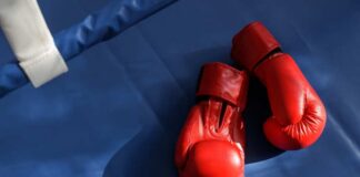 An empty boxing ring illuminated by bright lights in a sports arena