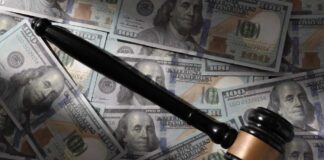 Judge’s gavel on scattered US hundred-dollar bills