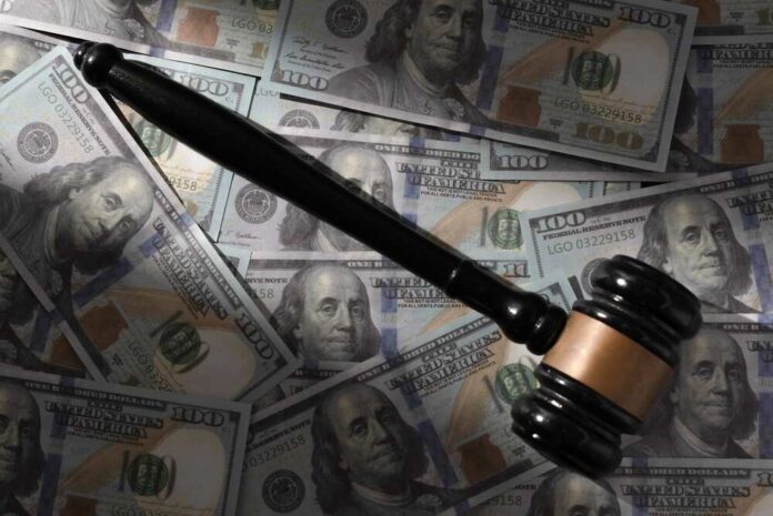 Judge’s gavel on scattered US hundred-dollar bills