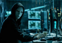 Rolling Spies? America Slams Door Shut Person in hoodie and mask using computer, multiple screens.