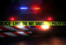 Nine Shootings, Nine Stories — Which Is Real? Police car with flashing lights behind caution tape.