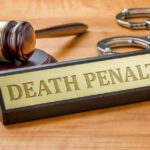 CONDEMNED: Death Sentence Handed Down Gavel handcuffs and death penalty sign on table