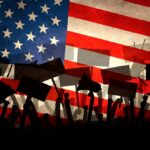 Silhouettes of protesters holding signs in front of an American flag