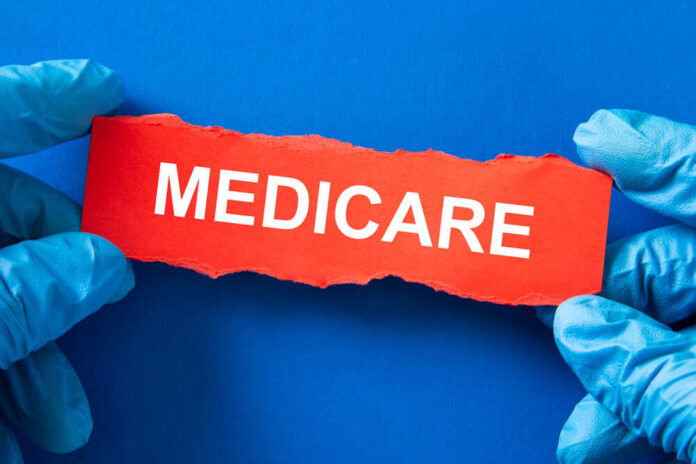 Doctor,Holds,A,Red,Paper,With,The,Word,Medicare,,Medical Gloved hands holding a torn red paper strip