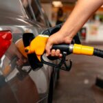 Gas Pain Craters Confidence A person refueling a car at a gas station