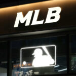Baseball Legend Dies — Name Changed Medicine Illuminated MLB sign above storefront window