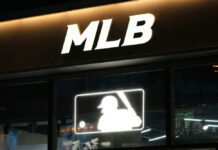 Baseball Legend Dies — Name Changed Medicine Illuminated MLB sign above storefront window