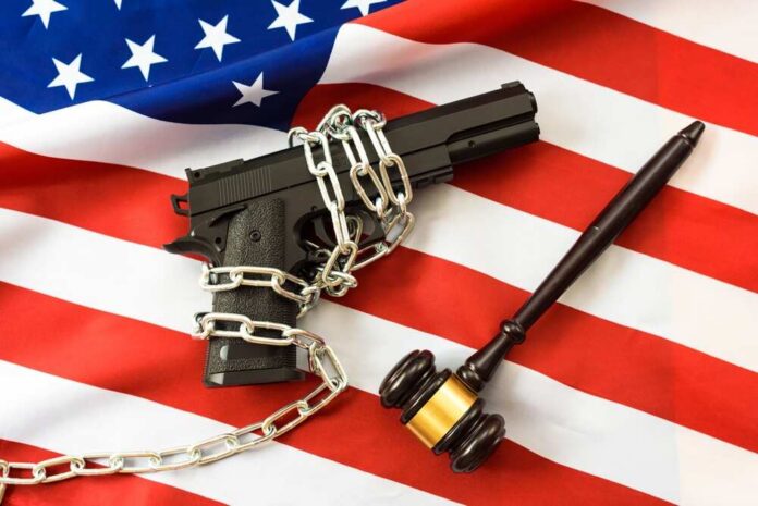 Judges,Rule,On,The,Use,Of,Civilian,Weapons,,Patriotic,Flag A handgun chained on an American flag with a gavel beside it
